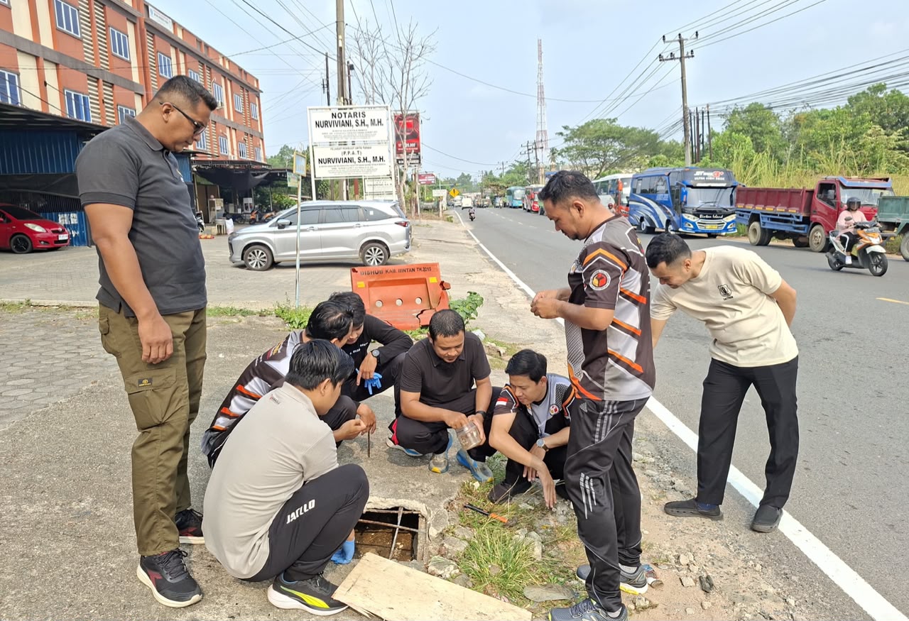 Pegawai Bawaslu Kabupaten Bintan bergotong royong memperbaiki saluran drainase di sekitar area parkir kantor dalam kegiatan Jumat Sehati, Jumat (11/9/2026)/Foto:Pemberitaan Bawaslu Bintan