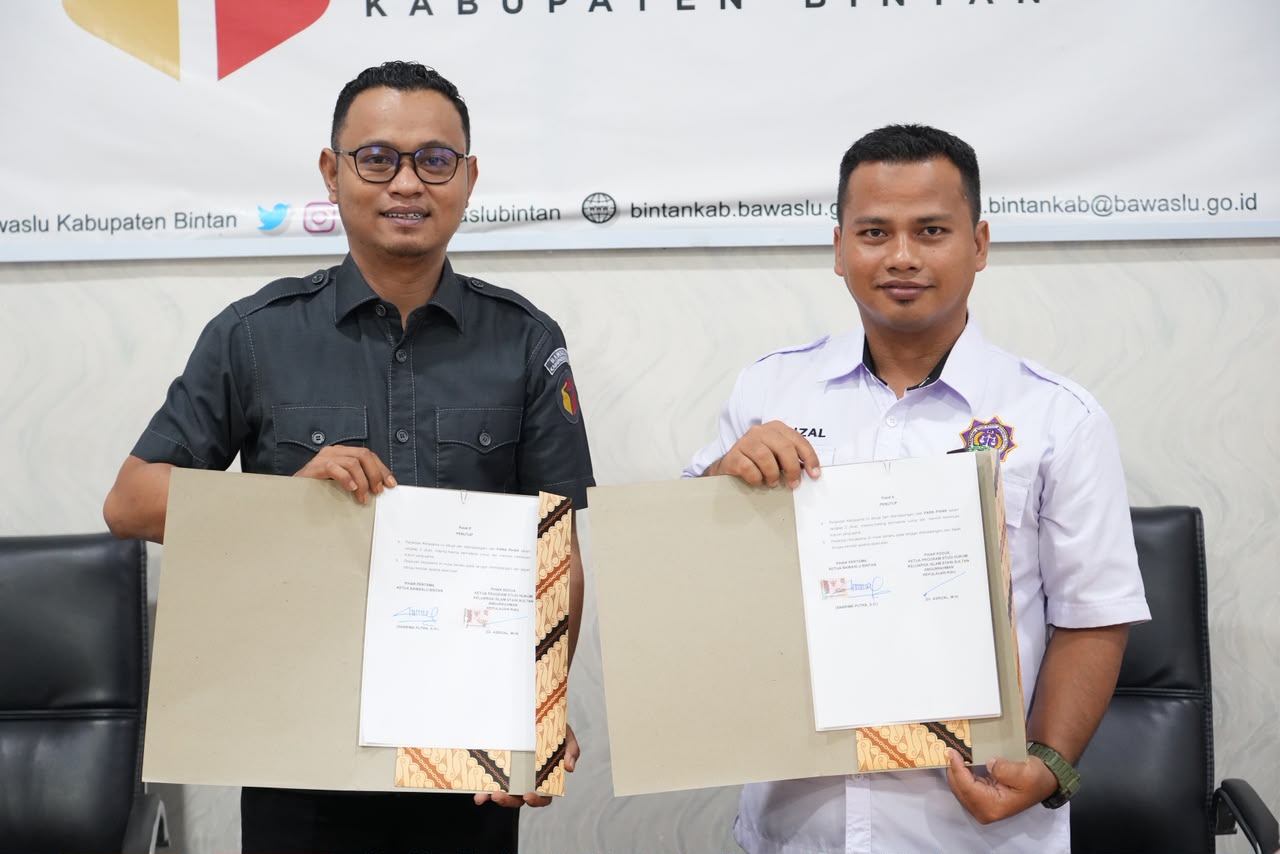 Ketua Bawaslu Kabupaten Bintan Sabrima Putra dan Ketua Program Studi Hukum Keluarga Islam STAIN Sultan Abdurrahman Kepulauan Riau Asrizal menunjukkan dokumen kerja sama Tridharma perguruan tinggi dan JDIH di Ruang Rapat Bawaslu Kabupaten Bintan, Selasa (15/9/2026)/Foto:Pemberitaan Bawaslu Bintan